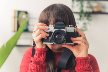 Dark haired European woman taking photo with a camera copy space medium closeup 