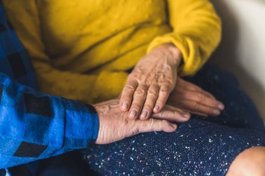 Closeup shot of caucasian wrinkled hands together. Elderly couple supporting each other.