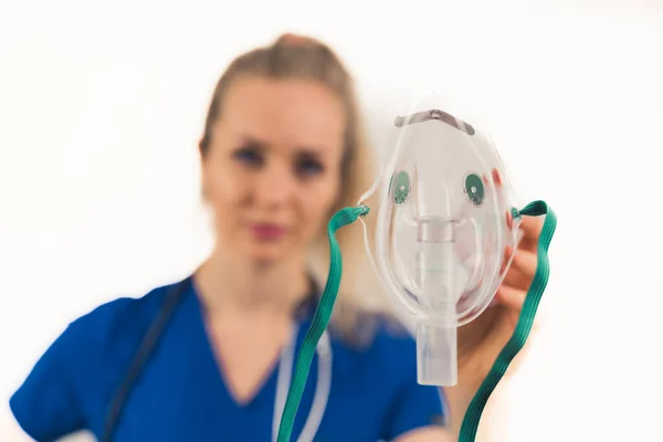 Studio Portret van vrouwelijke arts met zuurstofmasker over witte achtergrond. Focus op de voorgrond. — Stockfoto