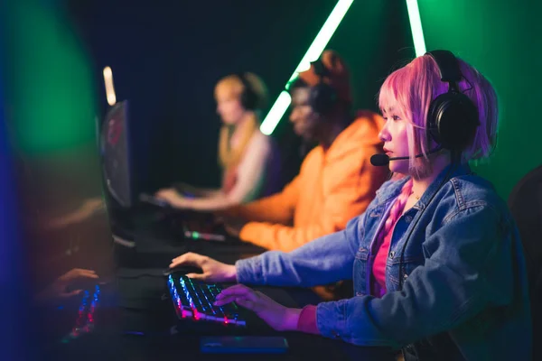 Chica joven con el pelo rosa jugando juegos en línea eSport concepto de tiro medio en el interior —  Fotos de Stock
