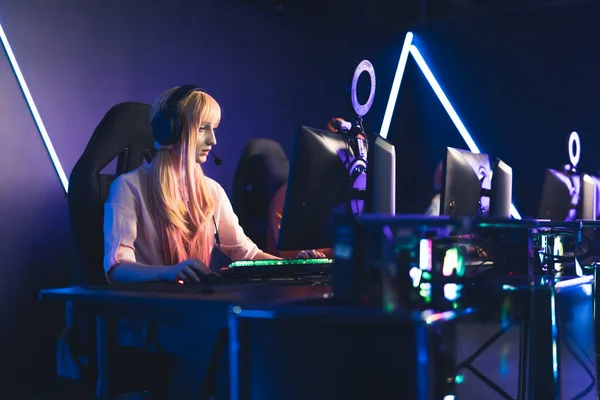 Blonde European girl playing in gaming tournament medium full shot indoors studio shot eSport concept —  Fotos de Stock