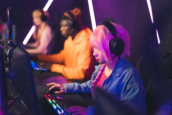 Chica de pelo rosa joven que participa en el torneo de videojuegos ciberdeporte concepto medio primer plano luces de neón en interiores —  Fotos de Stock