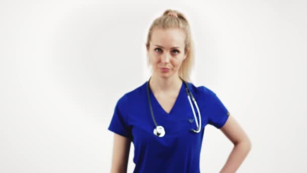 Luta contra o HIV, AIDS. Profissional de saúde do sexo feminino trabalhador em um uniforme azul mostrando fita vermelha com os dedos. Tiro médio do estúdio. — Vídeo de Stock