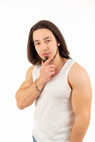 Young muscular man touching his beard and looking at the camera medium shot white background studio shot — Photo