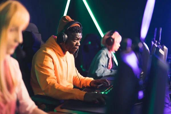 Jugador profesional de ciberdeporte con auriculares que se concentran en el juego con los miembros del equipo mientras juega videojuego en línea. torneo eSport cóncavo —  Fotos de Stock