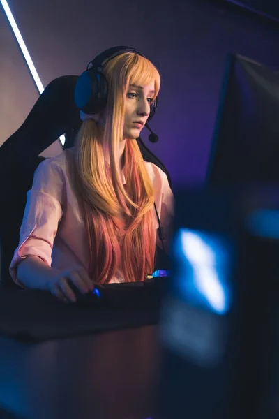 Young Caucasian professional gamer girl playing and streaming online game medium closeup indoors cyber sport concept neon light — Fotografia de Stock