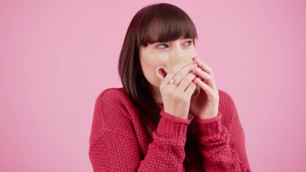 Gemütliche Stimmung. Schöne kaukasische junge Brünette trinkt langsam Tee oder Kaffee aus ihrer Lieblingstasse. Pinkfarbener Hintergrund, mittlere Studioaufnahme. — Stockvideo