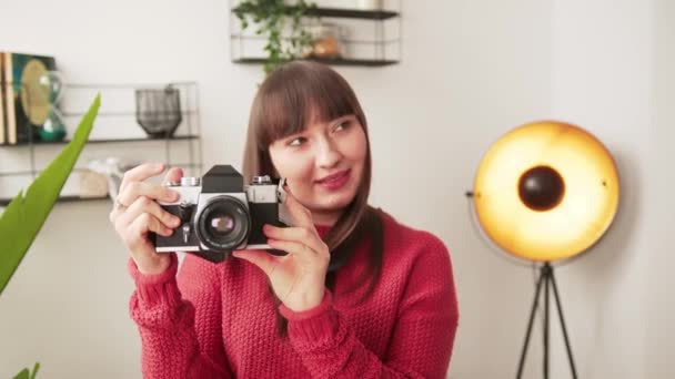 Young caucasian brunette freelance photography artist takes photo with her professional camera. Modern interior. — ストック動画