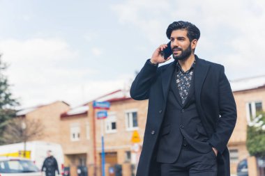 Latin çekici bir adam telefonda konuşuyor.