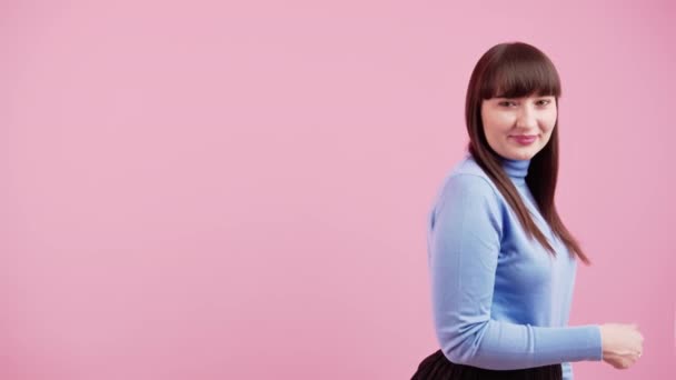 Mladá žena s úsměvem a stojící vyrobené palce nahoru na růžovém pozadí, izolované, studio copyspace — Stock video