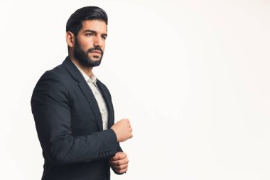 Takım elbiseli genç Latin bir adam kameradan uzağa bakan bir düğme hızlandırıyor, izole beyaz arka plan kopyalama alanı