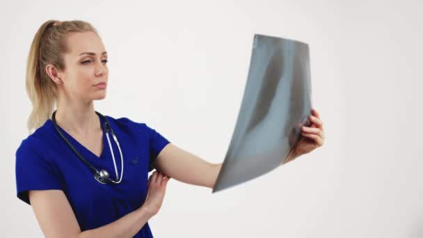 Female doctor examining x-ray of lungs medical concept white background studio shot medium closeup — стоковое видео