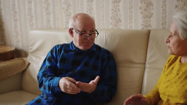 Roztomilý evropský senior pár mluvit půvabný na pohovce senioři podpora koncept střední shot indoors — Stock video