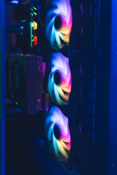 Vertical shot of colorful, rainbow-like professional computer gaming equipment. Working computer fans. — стоковое фото