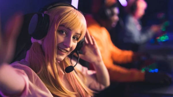 Selfie de joven caucásica jugador femenino en una peluca y auriculares sonriendo copiar los jugadores de espacio en el fondo —  Fotos de Stock