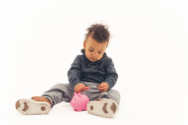 Young child putting coins into piggy bank, isolated white background — Photo