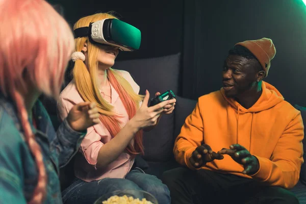 Interracial group of gamer friends trying out virtual reality goggle set for the first time. Shared experience. — Stockfoto