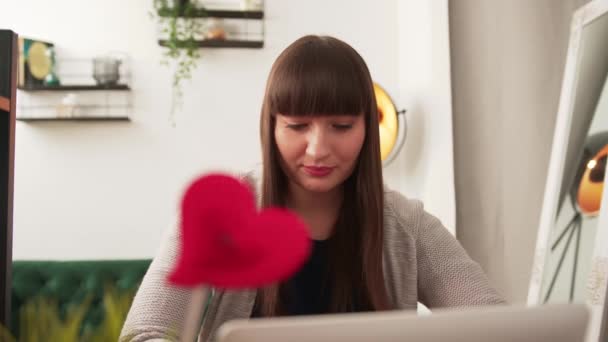 Schöne brünette Frau arbeitet an ihrem Laptop und denkt an etwas Wichtiges in ihrem Büro — Stockvideo