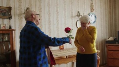 Orta yaşlı bir adam karısını evlilik yıldönümü konseptiyle tebrik ediyor. 