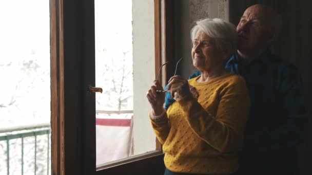 Senior coppia caucasica guardando attraverso la finestra, abbracciare e baciare copia spazio mezzo colpo — Video Stock