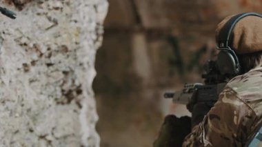 Çaylak bir kadın asker olarak otomatik tüfek tutan sağlam bir tutuş. 