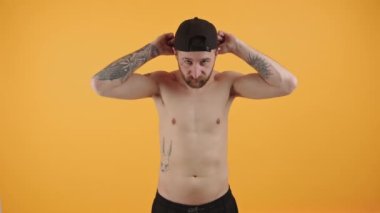 Yakışıklı beyaz sakallı adam şapkasını takıyor.