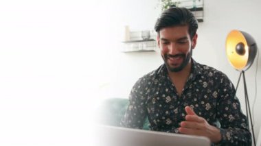 30 'lu yaşlardaki seksi, çekici sakallı bir adamın internet üzerinden iş görüşmesinde başkalarıyla iletişim kurmak için laptopunu kullanırken yarı bulanık görüntüsü. Modern iletişim konsepti.