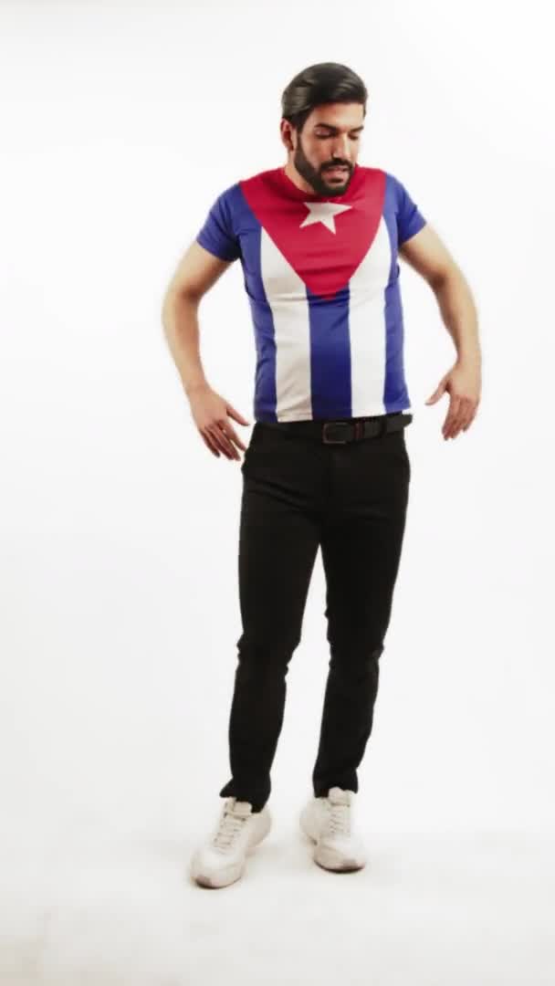 Full vertikal studio shot av en sexig förförisk säker snygg passform skäggig brunett man dansar med en t-shirt med kubansk flagga. Latinamerikansk dans. — Stockvideo