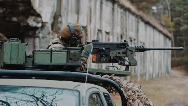 Bombarding machine gun gripped to a patrol unit army vehicle with operator — Stock Video