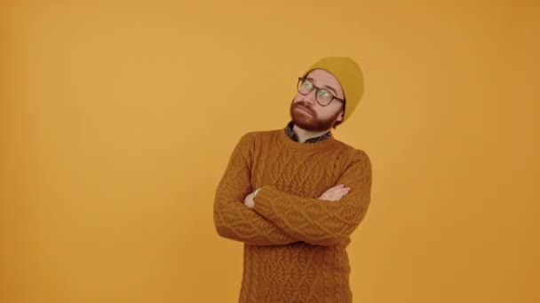 Jongeman met bril denken serieus oranje achtergrond medium schot kopieerruimte studio schot — Stockvideo