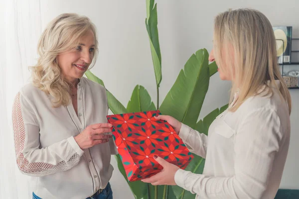 İnsanlar, tatiller ve aile kavramı - kızı ona mutlu bir anne hediyesi veriyor stüdyo arka planında, yatay