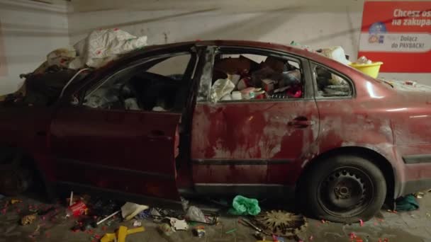Zniszczony czerwony samochód pełen śmieci na parkingu — Wideo stockowe