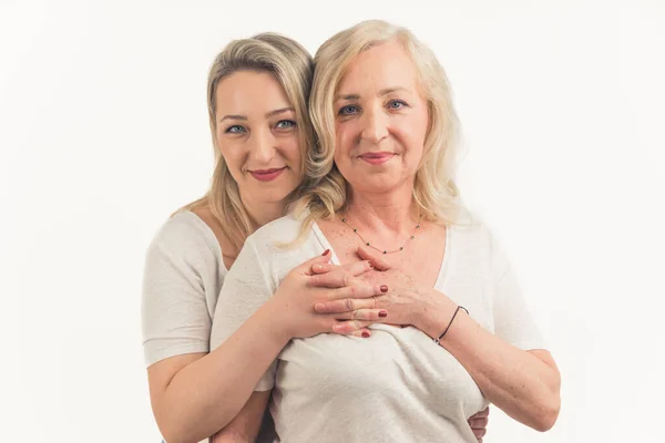 Vuxen dotter kramar leende blond mamma från ryggen, familj generation koncept — Stockfoto
