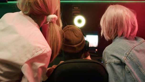 Back shot of a group of interracial female and male gamers cheering during an esports event. Man playing a game, girls supporting their friend. — стоковое видео