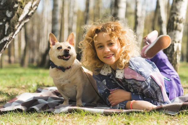 Young charming Caucasian girl resting in the park with her beloved dog full shot outdoors pet concept — Zdjęcie stockowe