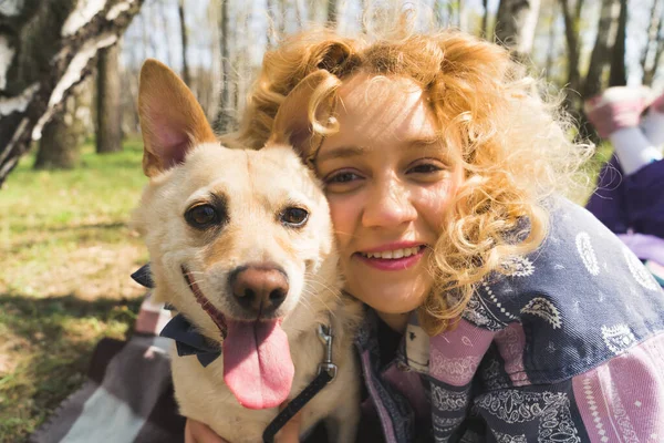 Selfie of a young blonde girl and her dog in the park medium closeup outdoors humans-animals friendship — Zdjęcie stockowe