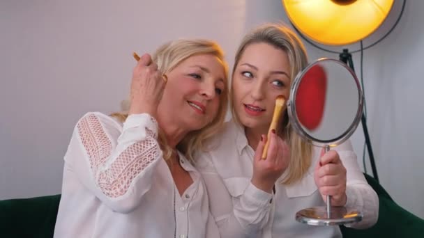 Indoor shot in an apartment of two confident attractive middle-aged women doing makeup preparing for a night out. — Vídeo de Stock