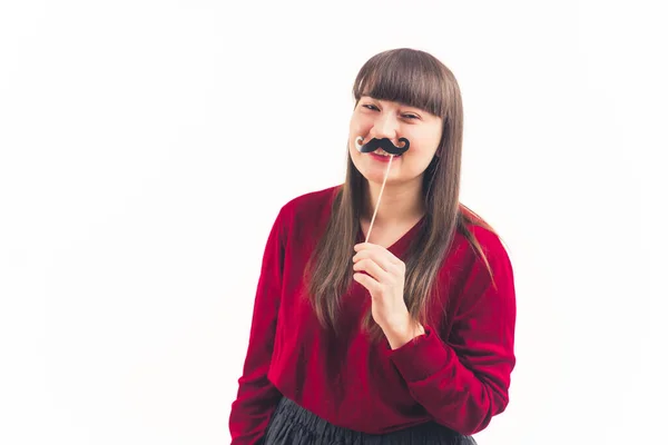 Pretty young woman holds fake moustache on a stick movember white background copy space isolated studio shot medium shot — 图库照片