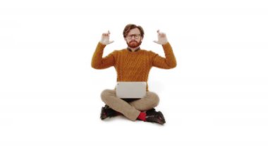 Genç beyaz sakallı adam dizüstü bilgisayarda çalışıyor ve şans diliyor.