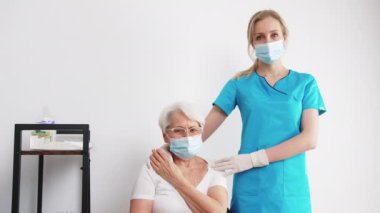 Genç sarışın hemşire orta yaşlı kadını destekliyor beyaz arka plan tıbbi ve yaşlı insanlar konsepti destekliyor