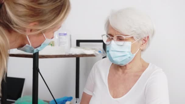 Medico donna dare consigli al suo paziente anziano presso l'ospedale medio close-up coperta assistenza sanitaria e concetto di anzianità — Video Stock