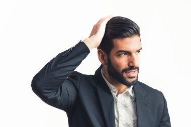 Genç ve çekici sakallı iş adamı saçını düzeltiyor ve yan tarafından bakıyor.
