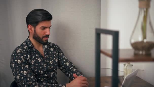 在一个视频通话中，一个穿着时髦休闲装的认真的拉丁裔男人在室内拍照，向他的同事解释了一些事情. — 图库视频影像