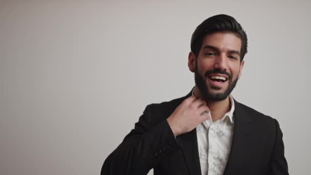 Giovane uomo latino attraente indossa un vestito elegante ridere e fissare i capelli. Concetto di imprenditore. — Video Stock