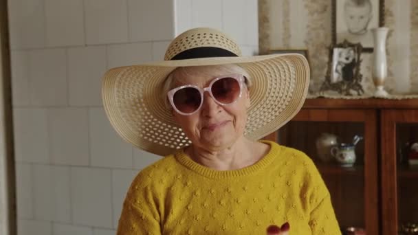 Oyuncu ve güzel son sınıf beyaz kadın pembe güneş gözlüklü ve şapkalı mutlu bir şekilde gülümseyen ev içi kıdem konsepti. — Stok video