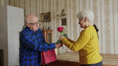 Sevgililer Günün kutlu olsun. Son sınıf öğrencisi, karısına gül ve hediye veriyor ve evde romantik bir kutlama konsepti sunuyor.