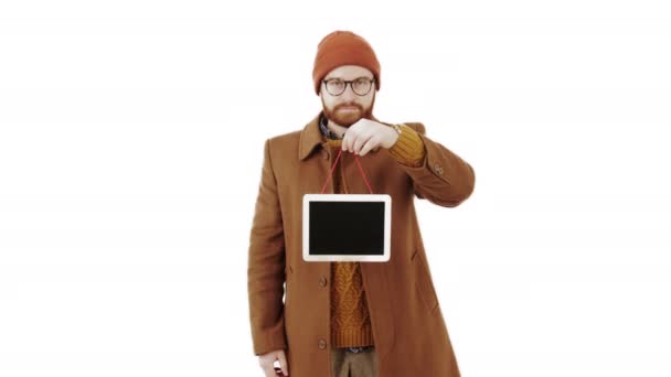 Vertikale Studioaufnahme eines gutaussehenden Hipsters in semi-eleganter Herbstbekleidung, der eine hölzerne Kopierraum-Tafel mit einer Hand über weißem Hintergrund hält. — Stockvideo