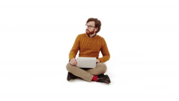 Koncepcja zakupów online. Kopiuj przestrzeń izolowane białe tło studio ujęcie białego człowieka w okularach, i broda trzymając laptopa na kolanach i patrząc na przestrzeń kopiowania. — Wideo stockowe
