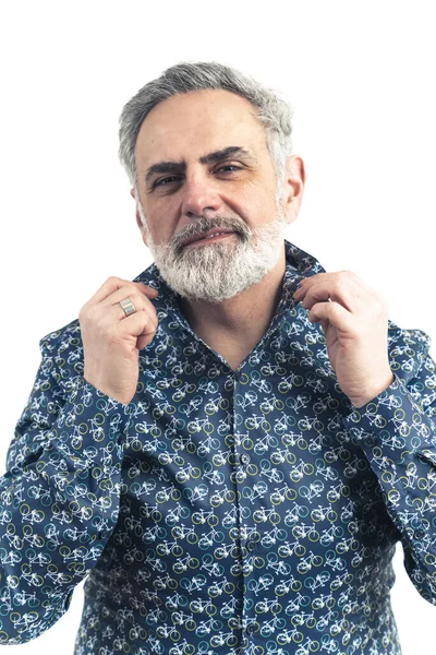 Serious hombre de edad avanzada de pelo gris de moda mirando a la cámara con una camisa estampada con bicicletas, la fijación de su cuello camisas. —  Fotos de Stock