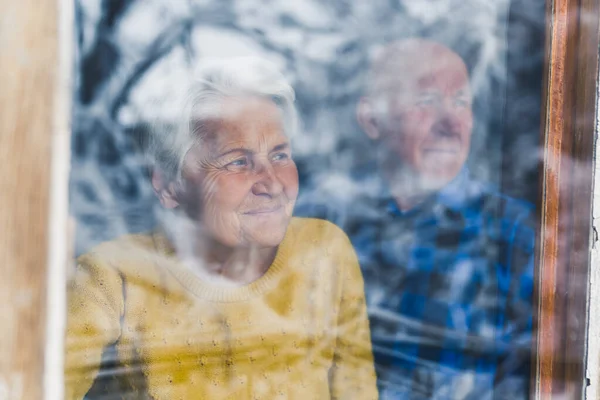 ホームメディアで窓を通して見ているシニアヨーロッパのカップルを愛し屋内の年功序列の概念 — ストック写真
